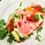 Molletes Toast with Black Bean Puree, Fried Egg & Pickled Red Onion